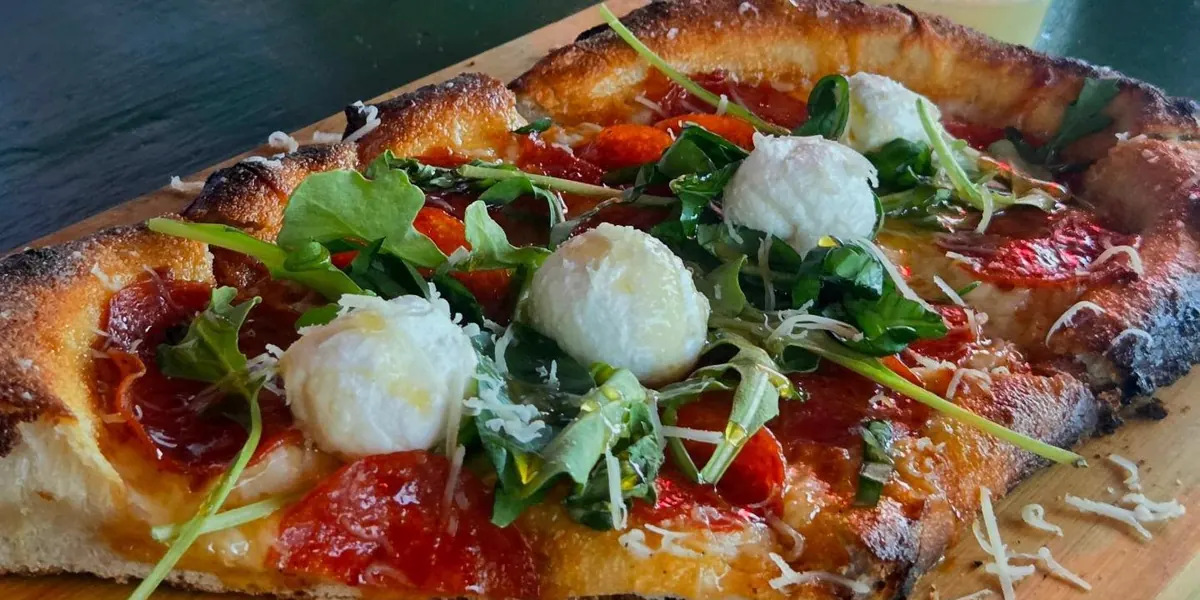 Close-up of a La Ricetta pizza crust on a wooden board
